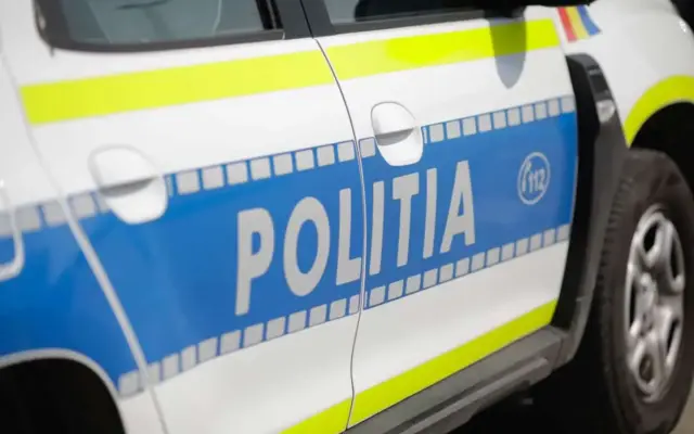 Detaliu lateral al unei autospeciale de poliție Dacia Duster din România, cu însemnele oficiale albastre și galben-fosforescente